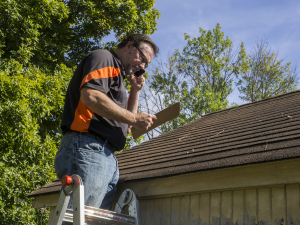 Roofer inspecting a Meadow Vista roof during the fall season.